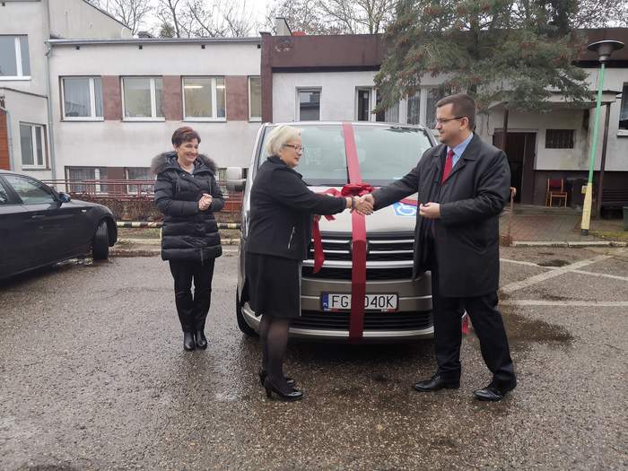 Pokaż zdjęcie: Dyrektor Oddziału Lubuskiego PFRON, Dyrektor DPS, Zastepca Prezydenta Miasta Gorzów Wlkp. stoją obok auta, z uroczystą szarfą, w trakcie oficjalnego przekazania samochodu dla DPS