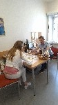 W siedzibie punktu CISON, przy biurku siedzi kobieta, odwrócona tyłem oraz pracownik PFRON i rozmawiają