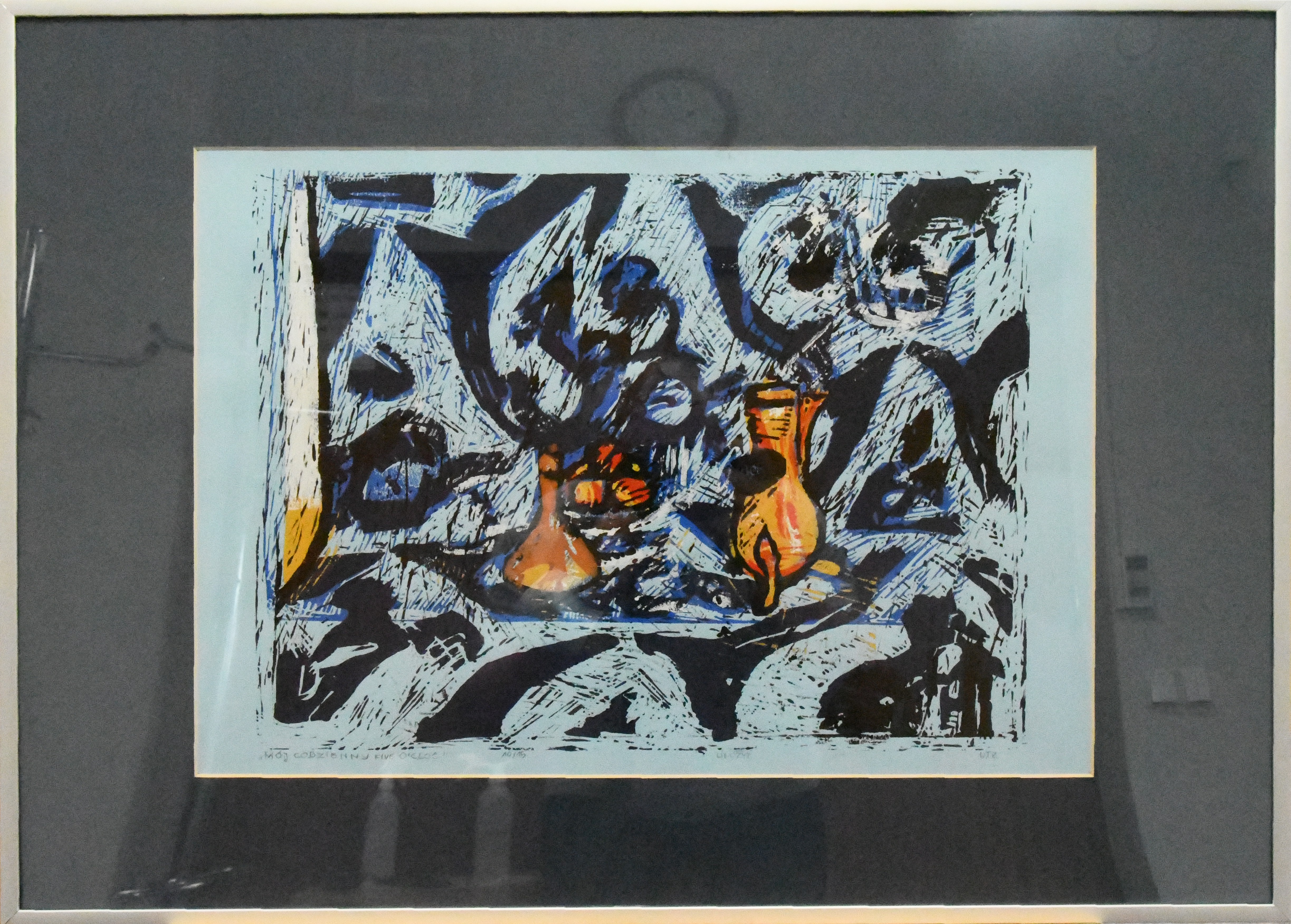 Tło rysunku stanowią nieregularne kształty w kolorze czerni z domieszką niebieskiego. W centrum rysunku zestaw do przygotowania herbaty, czajnik z naparem, czajnik z gorącą wodą, filiżanki.