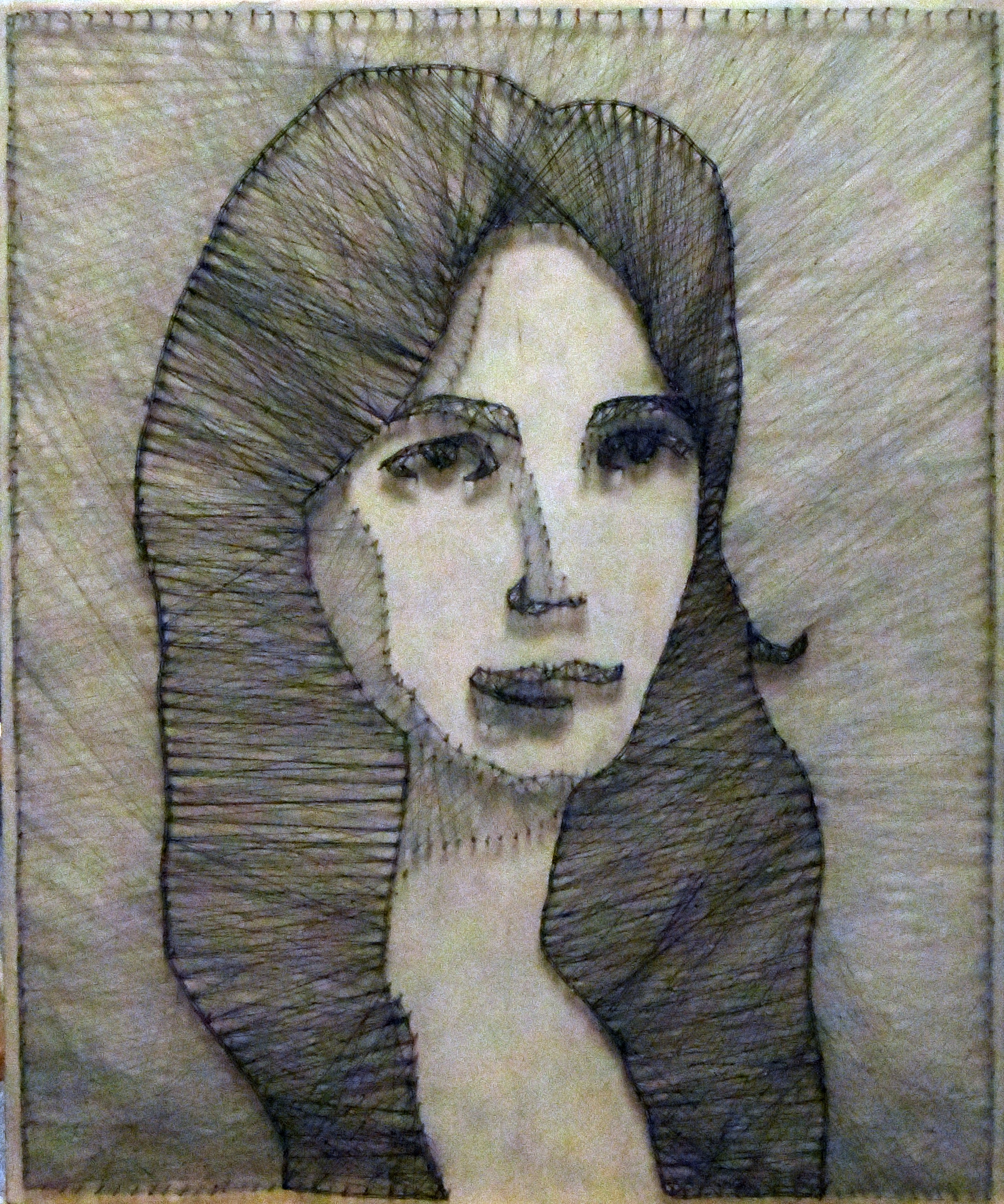 Czarno biały portret kobiety. Na deskę zawierając szkic, zostały wbite gwoździki a następnie, poprzez wielokrotne nawijanie pomiędzy gwoździkami czarnej nitki uzyskano portret.  