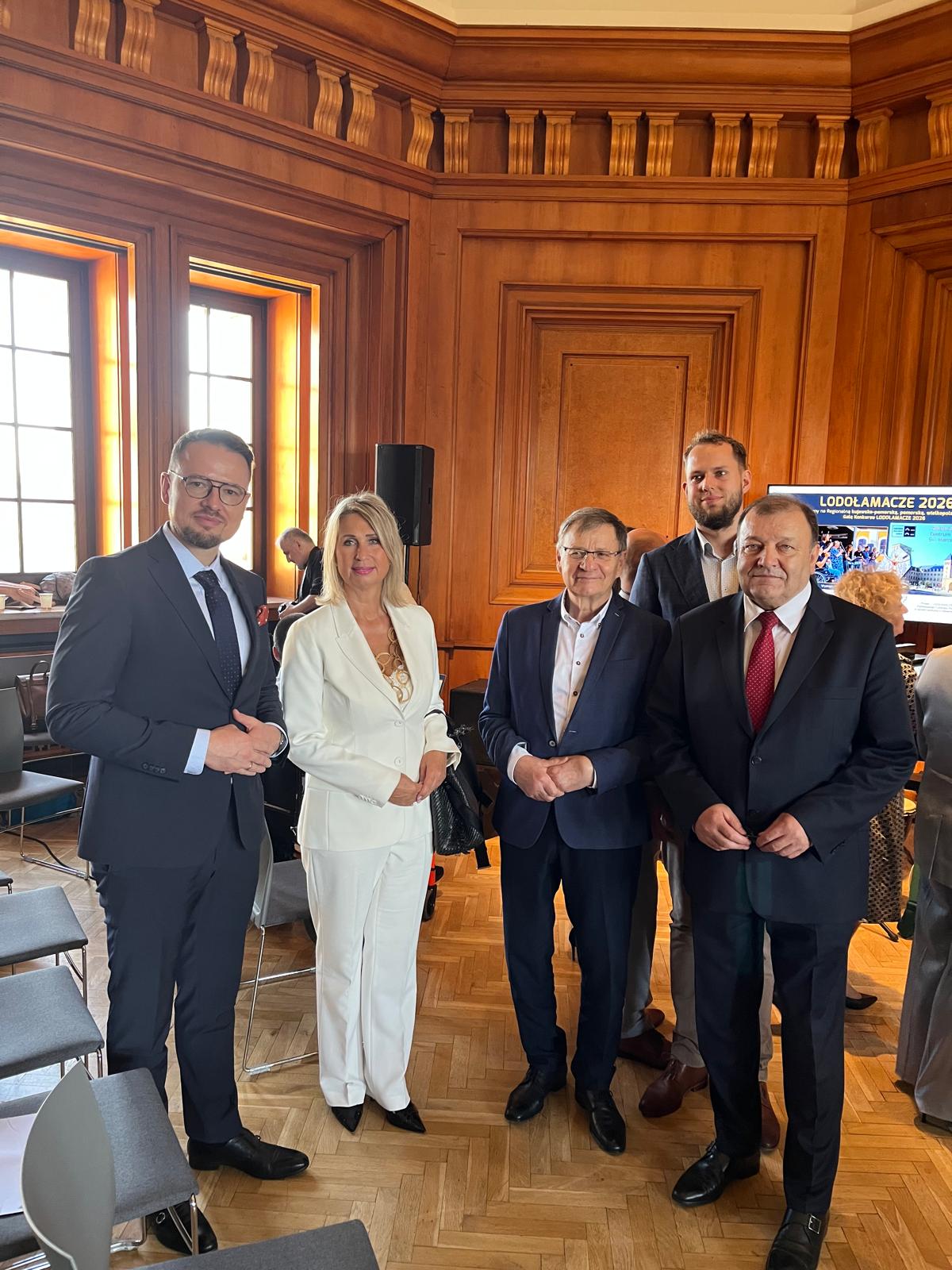 Cztery osoby pozują do zdjęcia w reprezentacyjnej, drewnianej sali Centrum Kultury „Zamek” w Poznaniu podczas Gali Lodołamacze 2026. W tle widoczny ekran z informacją o konkursie.