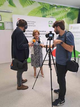 Dyrektor Kujawsko-Pomorskiego Oddziału PFRON podczas udzielania wywiadu dla lokalnej telewizji, w tle ścianka CIDON PFRON