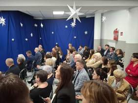 Pokaż zdjęcie: Zdjęcie sali w której na krzesełkach siedzą zaproszeni goście.