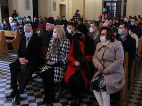 Pokaż zdjęcie: miejsce kościół w Ozorkowie, po obu stronach drewniane ławki na których siedzą zaproszeni goście