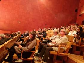 Pokaż zdjęcie: na zdjęciu sala koncertowa na której siedzą na krzesłach zaproszeni goście i uczestnicy konkursu plastycznego i ich podopieczni