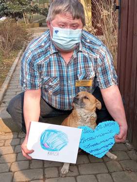 Pokaż zdjęcie: Uczestnik WTZ MADA z sercem przygotowanym na obchody Światowego Dnia Świadomości Autyzmu. Na zdjęciu również pies uczestnika zajęć.