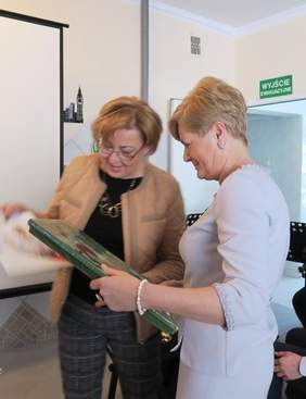 Pokaż zdjęcie: Dyrektor Marta Mordarska przekazuje obraz dyrektor Ewie Chłandzie (źródło Starostwo Powiatowe w Gorlicach)