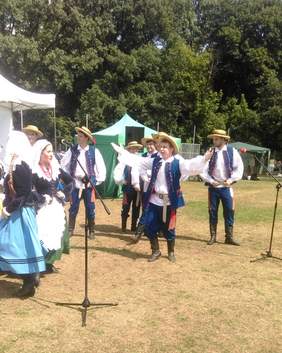 Pokaż zdjęcie: Grupa młodzieży w strojach ludowych tańcząca przy scenie - Warszawa.