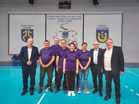 Pokaż zdjęcie: Na zdjęciu kilku uczestników turnieju pozujących do zdjęcia z Dyrektorem Oddziału Świętokrzyskiego PFRON, Starostą Powiatu Pińczowskiego oraz Kierownikiem WTZ