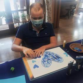 Pokaż zdjęcie: Pan Maciej przygotowuje niebieskie serce - przygotowania do obchodów Światowego Dnia Świadomości Autyzmu