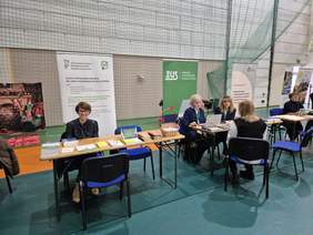 Punkty informacyjne. Za nimi widać banery instytucji.