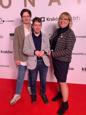 Pokaż zdjęcie: Kobieta i dwóch młodych mężczyzn. Wszyscy stoją na czerwonym dywanie, w tle ścianka z napisem "Sonata"