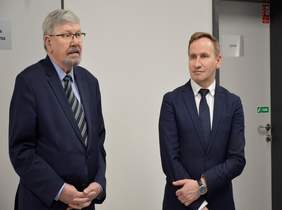 Pokaż zdjęcie: Na zdjęciu znajdują się dwie osoby ubrane w granatowe garnitury. Osobą po lewej stronie fotografii jest dyrektor Oddziału Łódzkiego. Po prawej stronie ilustracji jest przewodniczący Zarządu Koła. 