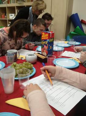 Pokaż zdjęcie: Grupa osób siedzących przy stoliku