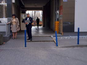 Pokaż zdjęcie: Podjazd od strony parkingu, trzy osoby stoją, jedna trzyma w ręku notebooka