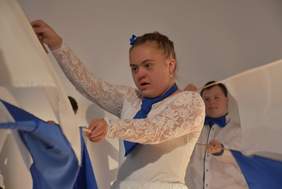 Pokaż zdjęcie: Występy artystyczne zaprezentowane w trakcie obchodów jubileuszowych. Młoda dziewczyna na scenie, tańczy w białym stroju