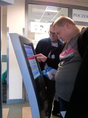 Uczestnicy WTZ uczą się korzystać z biletomatu w NFZ