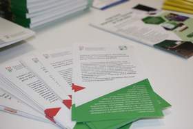 Ulotki informacyjne dla osób z niepełnosprawnościami rozłożone na stole podczas wydarzenia informacyjnego PFRON.