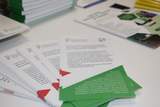 Ulotki informacyjne dla osób z niepełnosprawnościami rozłożone na stole podczas wydarzenia informacyjnego PFRON.