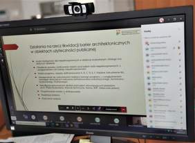 Pokaż zdjęcie: Szkolenie webinarowe PFRON i BGK - na zdjęciu ekran komputera i slajd prezentacji dotyczącej likwidacji barier architektonicznych 