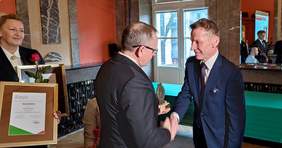 Pokaż zdjęcie: Dyrektor Oddziału Świętokrzyskiego PFRON Andrzej Michalski gratuluje dziennikarzowi Radia Kielce  Pawłowi Solarzowi nagrody "Burzyciela Barier"