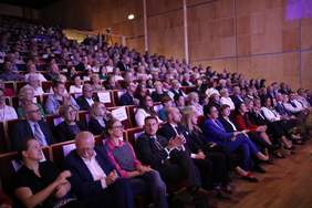 Pokaż zdjęcie: Publiczność zgromadzona na wydarzeniu, skupiona na wystąpieniu artysty na scenie