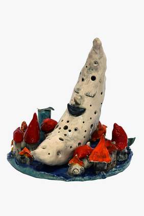 Pokaż zdjęcie: Rzeźba przedstawiająca uśmiechnięty księżyc, a wokół niego małe domki