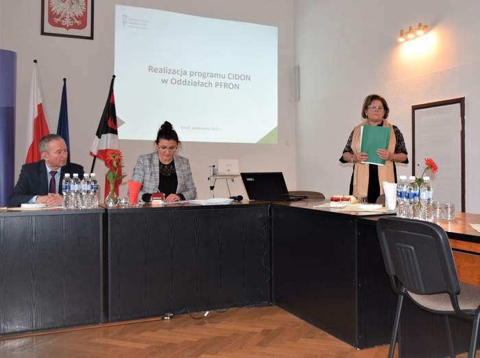 Pokaż zdjęcie: Dyrektor Kujawsko-Pomorskiego Oddziału PFRON Aleksandra Gierej podczas wystąpienia, w tle na ekranie widnieje temat: Realizacja programu CIDON w Oddziałach PFRON