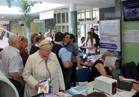 Pokaż zdjęcie: Uczestnicy wydarzenia zebrani wokół punktów konsultacyjnych