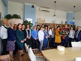 Liczna grupa uczestników spotkania, mężczyźni i kobiet stoją i pozują do zdjęcia