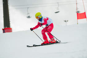 Narciarz alpejski, aura zimowa, biały śnieg, słoneczny dzień.