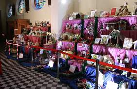 Pokaż zdjęcie: na zdjęciu prace plastyczne szopki bożonarodzeniowe wykonane przez osoby z niepełnosprawnością  kolorowe szopki rozmieszczone w kościele