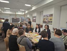 Pokaż zdjęcie: Zdjęcie przedstawia warsztaty w Sokółce. Uczestnicy, w tym osoby z niepełnosprawnościami, pracują w małych grupach nad przygotowaniem wniosku lub skargi. 