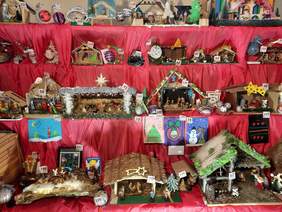 Pokaż zdjęcie: W kilku rzędach znajduje się wiele szopek bożonarodzeniowych. Są wykonane różnymi metodami artystycznymi i plastycznymi. 