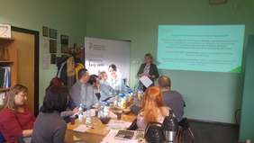 Pokaż zdjęcie: Uczestnicy spotkania i pracownik prowadzący spotkanie