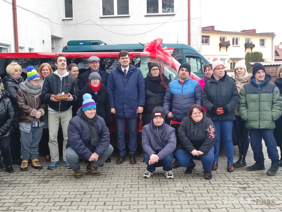 Pokaż zdjęcie: Grupa osób na tle czerwonego samochodu