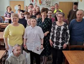 Grupa uczestników Środowiskowego Domu Samopomocy w Krotoszynie pozuje do wspólnego zdjęcia. Większość osób stoi w rzędach, a jedna osoba siedzi na przodzie.