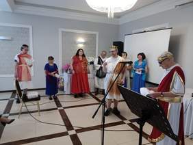 Pokaż zdjęcie: Na scenie artyści przebrani za greckich bogów przedstawiają ich atrybuty i recytują wiersze