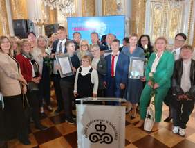 Pokaż zdjęcie: Duża grupa osób pozuje do pamiątkowego zdjęcia.