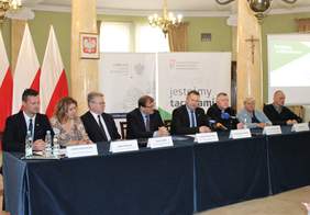 Pokaż zdjęcie: Prezydium konferencji przy stole konferencyjnym