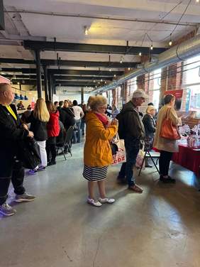 Pokaż zdjęcie: W sali znajduje się tłum ludzi. Są to uczestnicy Tagów Pracy dla Osób z Niepełnosprawnościami. Pod ścianami ustawione są różne stoiska pracodawców i instytucji.  