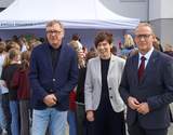 Oficjalne wydarzenie plenerowe. Od lewej stoją: Marek Machiński - dyrektor Szkoły Podstawowej nr 8 w granatowej marynarce, Anna Skupień - dyrektor Oddziału Wielkopolskiego PFRON w szarym żakiecie oraz prezydent Miasta Gniezna Michał Powałowski w garniturze z bordowym krawatem. W tle grupa młodzieży, biały namiot i ściana budynku.