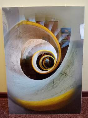 Pokaż zdjęcie: Na zdjęciu znajduje się praca plastyczna, która zdobyła wyróżnienie w kategorii „Fotografia”. Jest to ujęcie na którym widać spiralę schodów w budynku. 