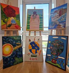 Pokaż zdjęcie: 6 kolorowych obrazów namalowanych farbami. Obrazy są ułożone na trzech sztalugach. 