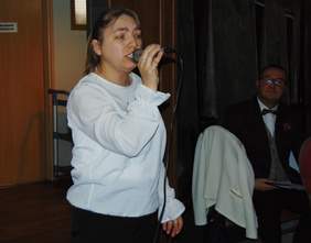 Pokaż zdjęcie: Kobieta śpiewa do mikrofonu 