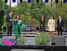 Pokaż zdjęcie: Oficjalne otwarcie Festiwalu. Na scenie stoją kobiety i mężczyźni - gospodarze i goście honorowi.