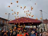 Przed sceną tłum, unoszące się w niebo pomarańczowe balony.