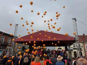 Przed sceną tłum, unoszące się w niebo pomarańczowe balony.