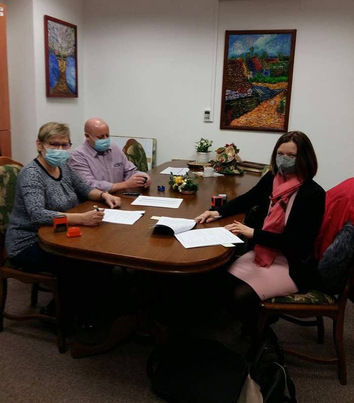 Pokaż zdjęcie: Za stołem siedzą pracownicy oddziału mazowieckiego PFRON, Pani Beata Noceń oraz Arkadiusz Krawczyk. Naprzeciwko siedzi Pani Malwina Wysocka-Dziuba,  Prezes Zarządu Fundacji. Na stole dokumenty, które mają zostać podpisane.