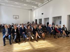 Pokaż zdjęcie: Sala konferencyjna, na krzesełkach ustawionych w rzędach siedzą zaproszeni goście